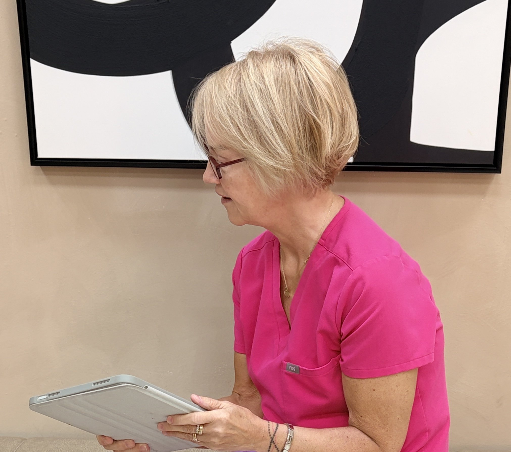 Sandra reviewing client information during an aesthetic consultation at Aesthetics by Sandra 