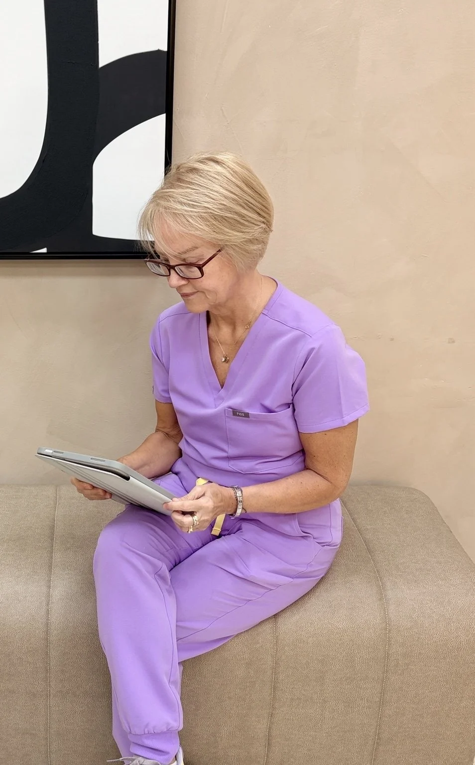 Sandra, aesthetic practitioner and independent prescriber in clinic carrying out face to face consultation