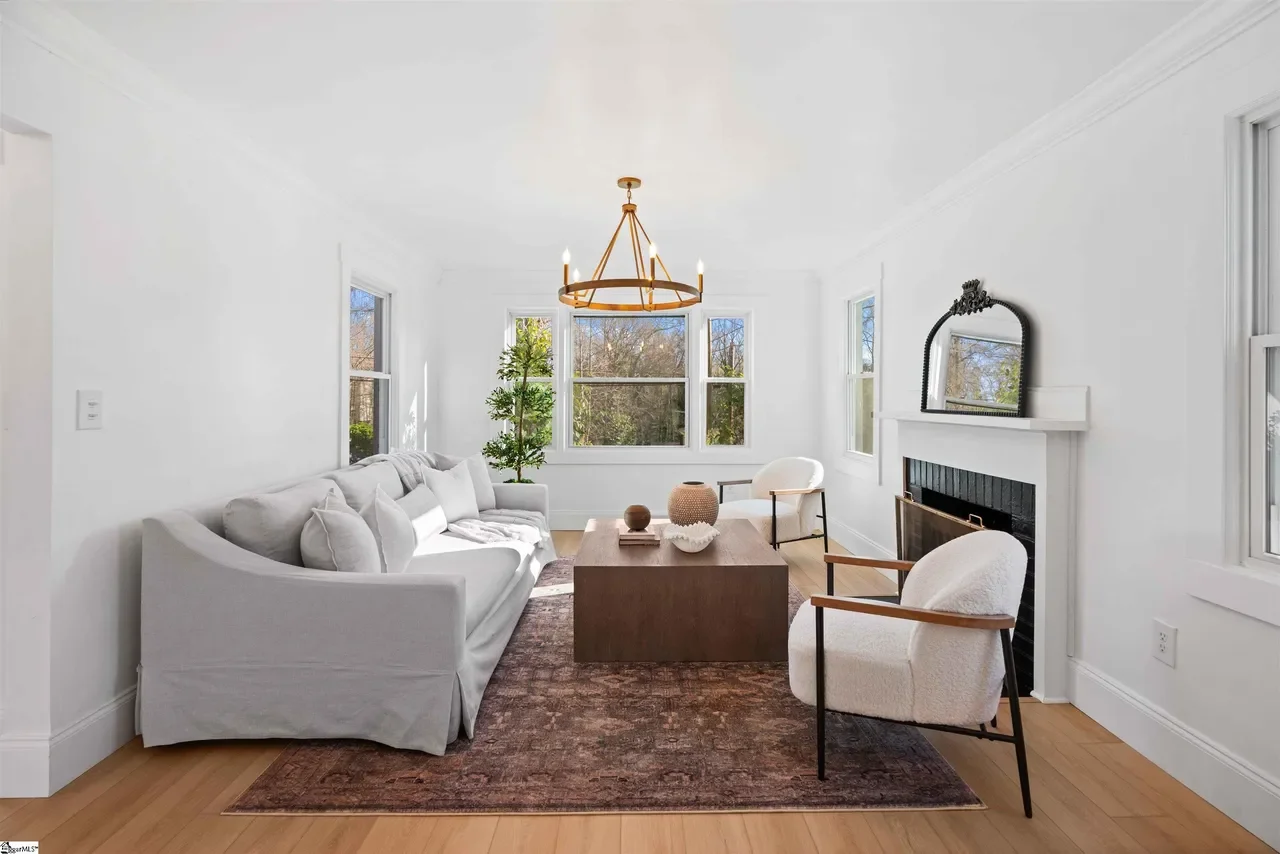 Modern minimalist bathroom with a floating vanity, large mirror, and a bathtub near frosted glass windows, featuring neutral tones and natural light. No matter what your day brings getting home to this serene bathroom takes off the stress of the day
