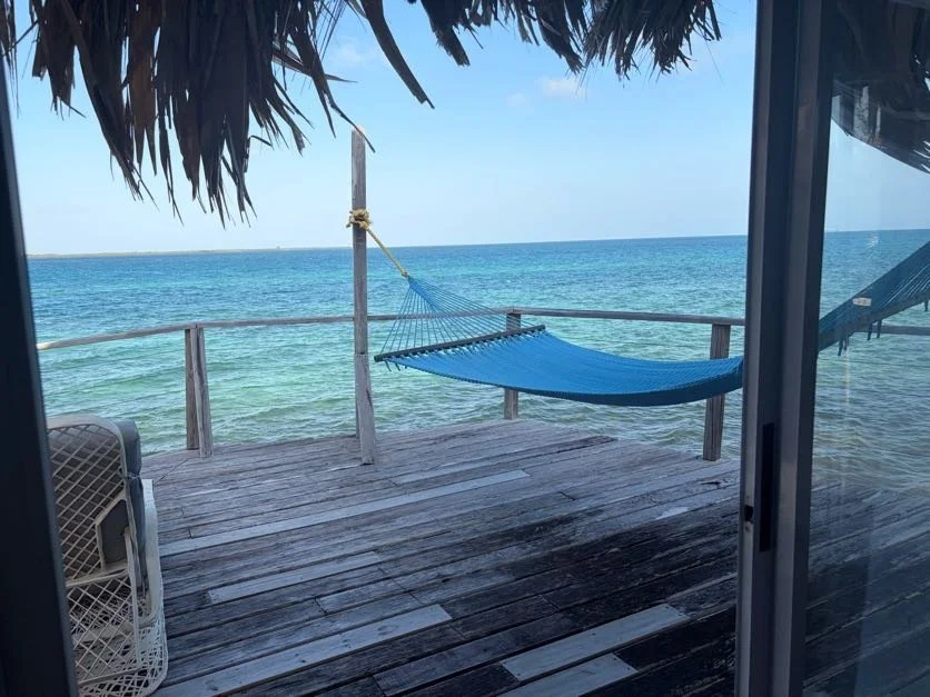 A hammock on a balcony over the water
