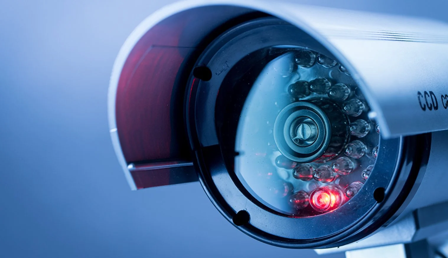 Close-up of a medical or scientific device with a glowing red light, circular glass components, and metallic parts.