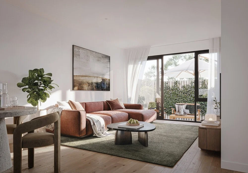 Modern living room with a pink sofa, abstract wall art, a round coffee table, green rug, and sliding glass door leading to a balcony with outdoor furniture and umbrella.
