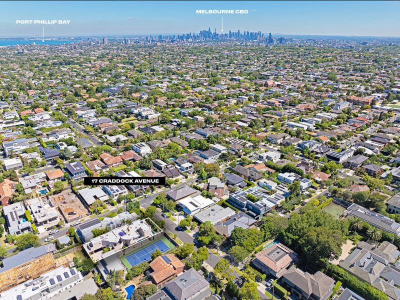 Aerial view of a residential neighborhood in Melbourne, Australia, with the city skyline in the background, pointing out Port Phillip Bay, Melbourne CBD, and a specific address 17 Craddock Avenue.