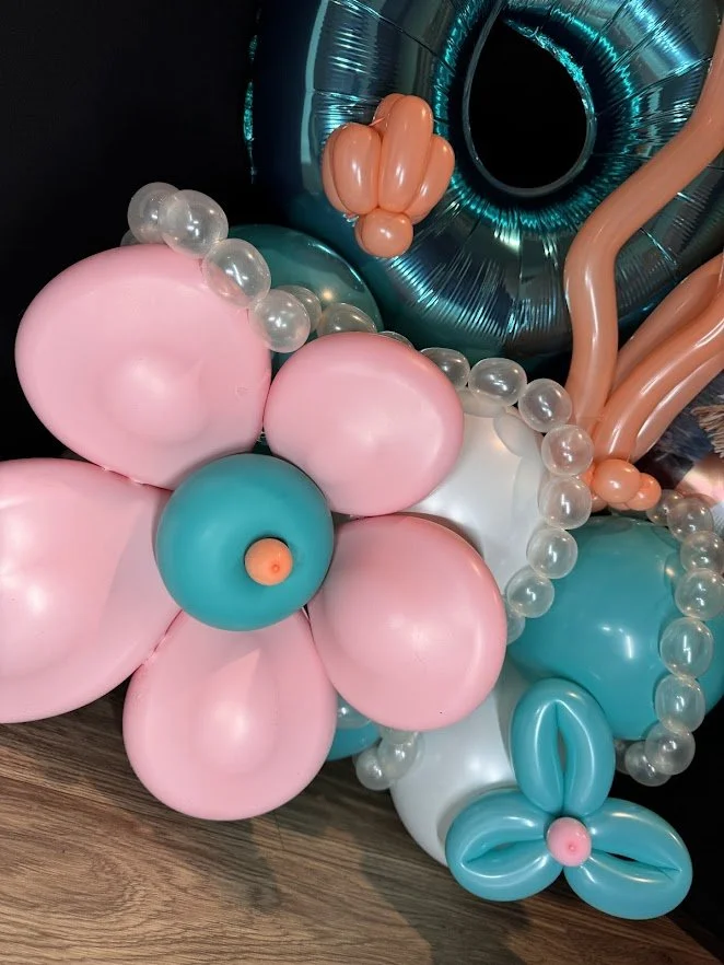 Character Stack with teal and white balloons, teal number 6, Moana balloons, coral and sea shell balloons, and 3D flower balloon