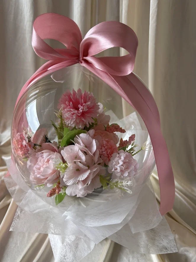 Stuffed bubble balloon with pink flower bouquet.