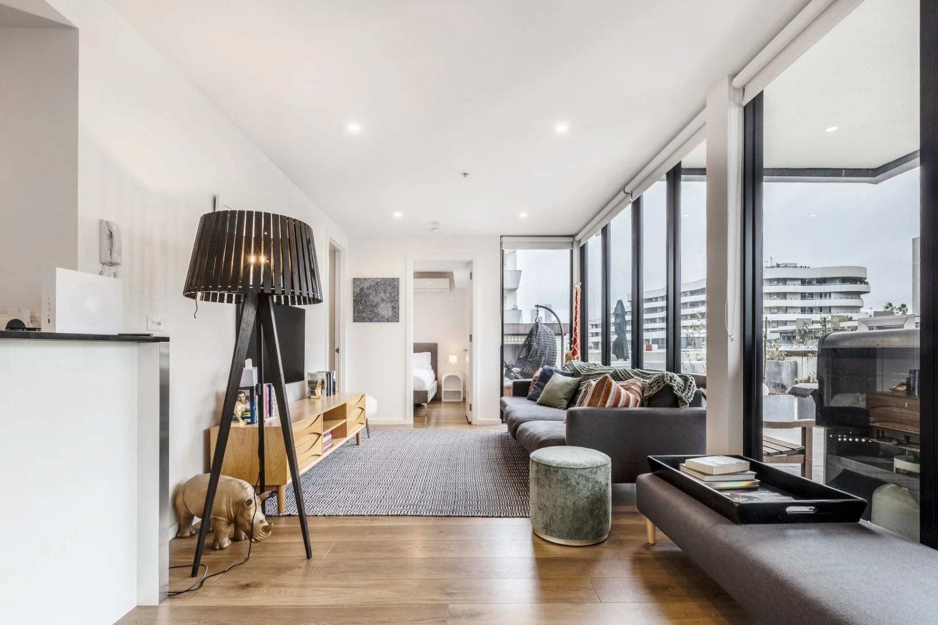 Professionally shot open, well lit lounge room of an Airbnb listing in Port Melbourne, offering even lighting to minimise shadows and create an inviting space for the viewer.
