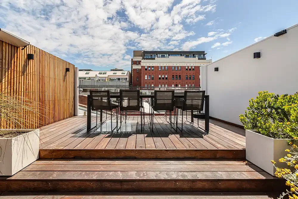 Spacious rooftop deck with an 8-seater dining table, captured to boost bookings for a Melbourne short-stay property.