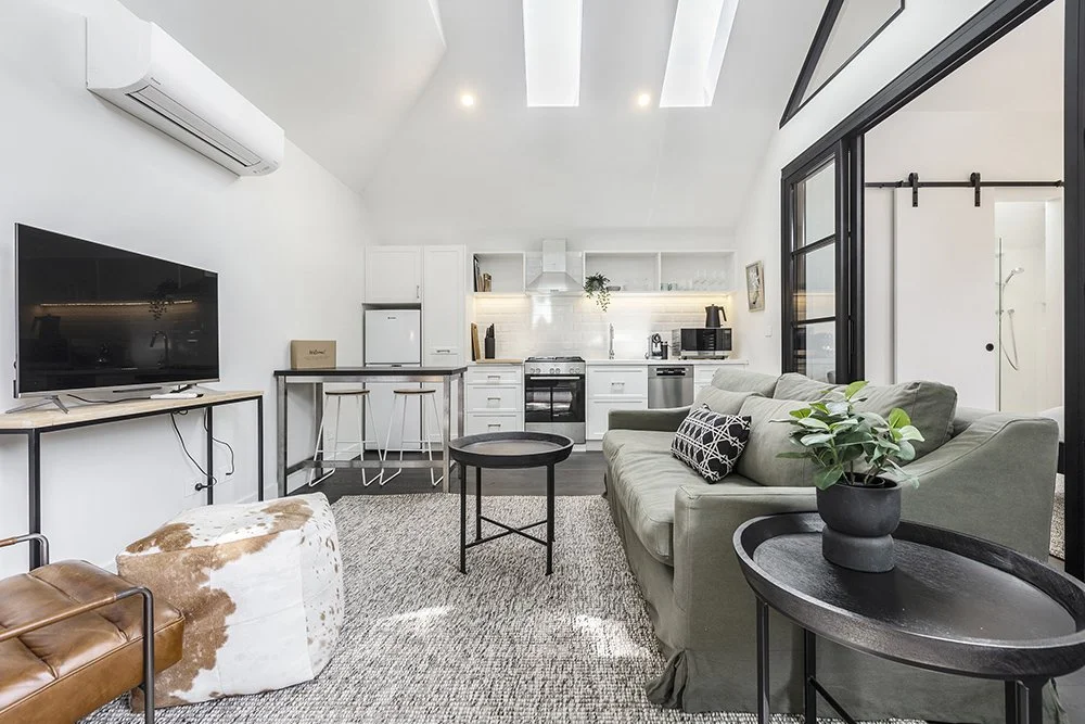Interior of an Airbnb apartment in Prahran, Melbourne with stark white high ceilings and skylights.