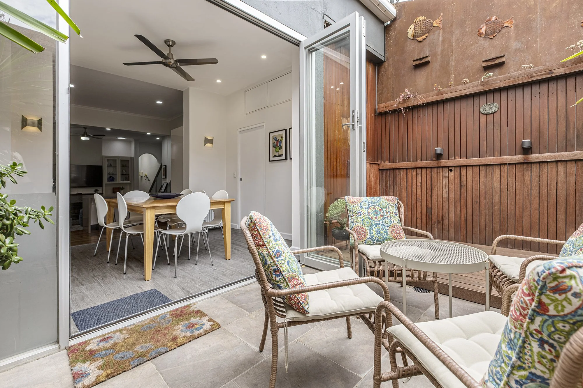 Private courtyard with outdoor seating opening onto a North Melbourne Airbnb dining room