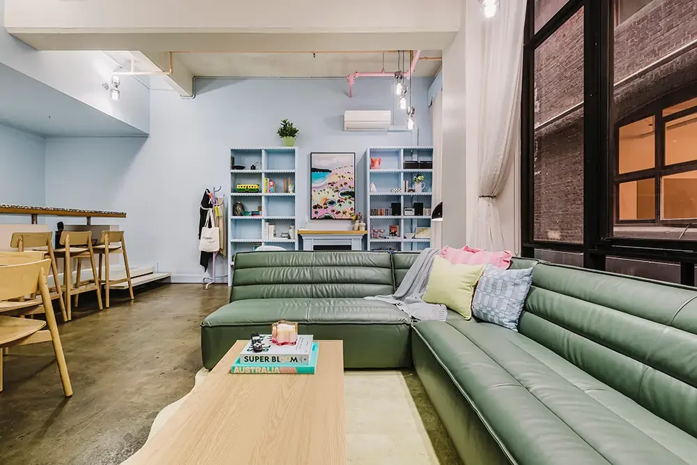 Stylish Flinders Lane basement lounge with blue and green pastel tones, professionally photographed for a city Airbnb.
