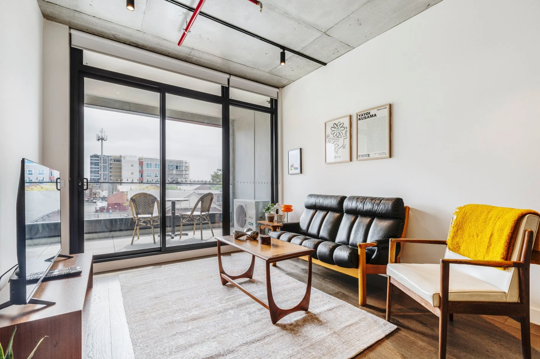Clean walls and a mid-century industrial style blend to create a city apartment vibe that guests keep returning to., at this Southbank Airbnb in Melbourne.