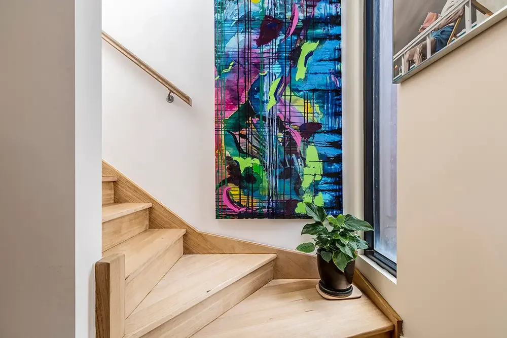 Artistic detail of a wooden staircase with a pot plant, highlighting architectural photography expertise in Melbourne.