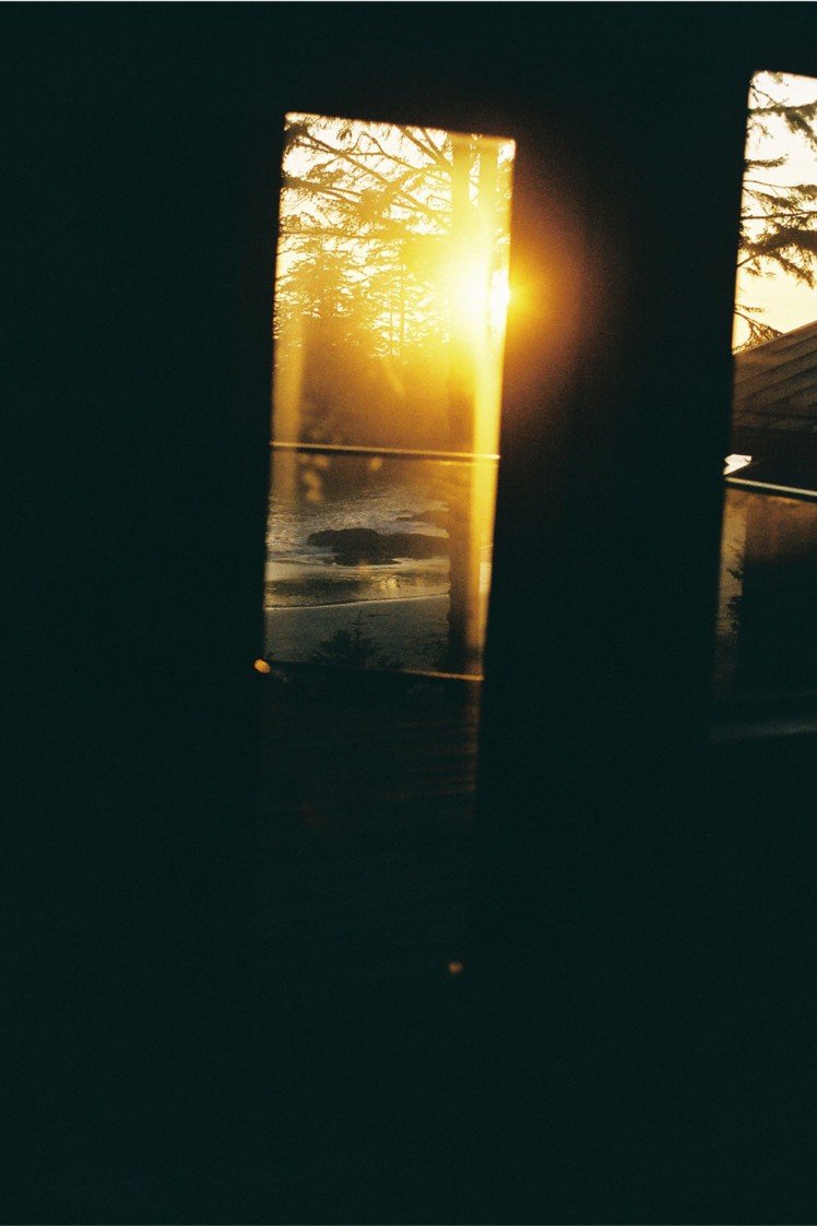 Sunset view through window with trees and water outside