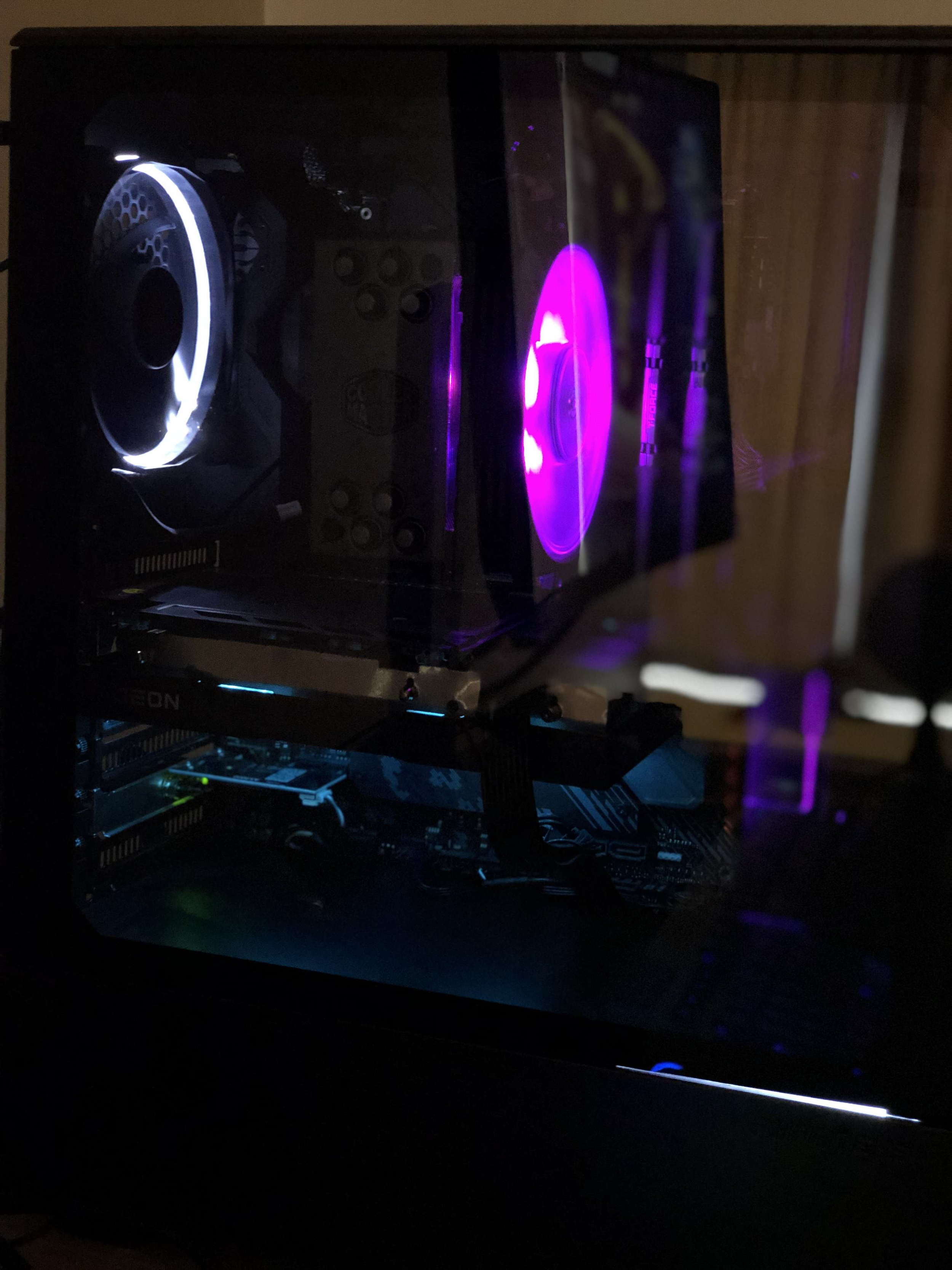 Dark computer case with illuminated purple and white LED fans and internal components.