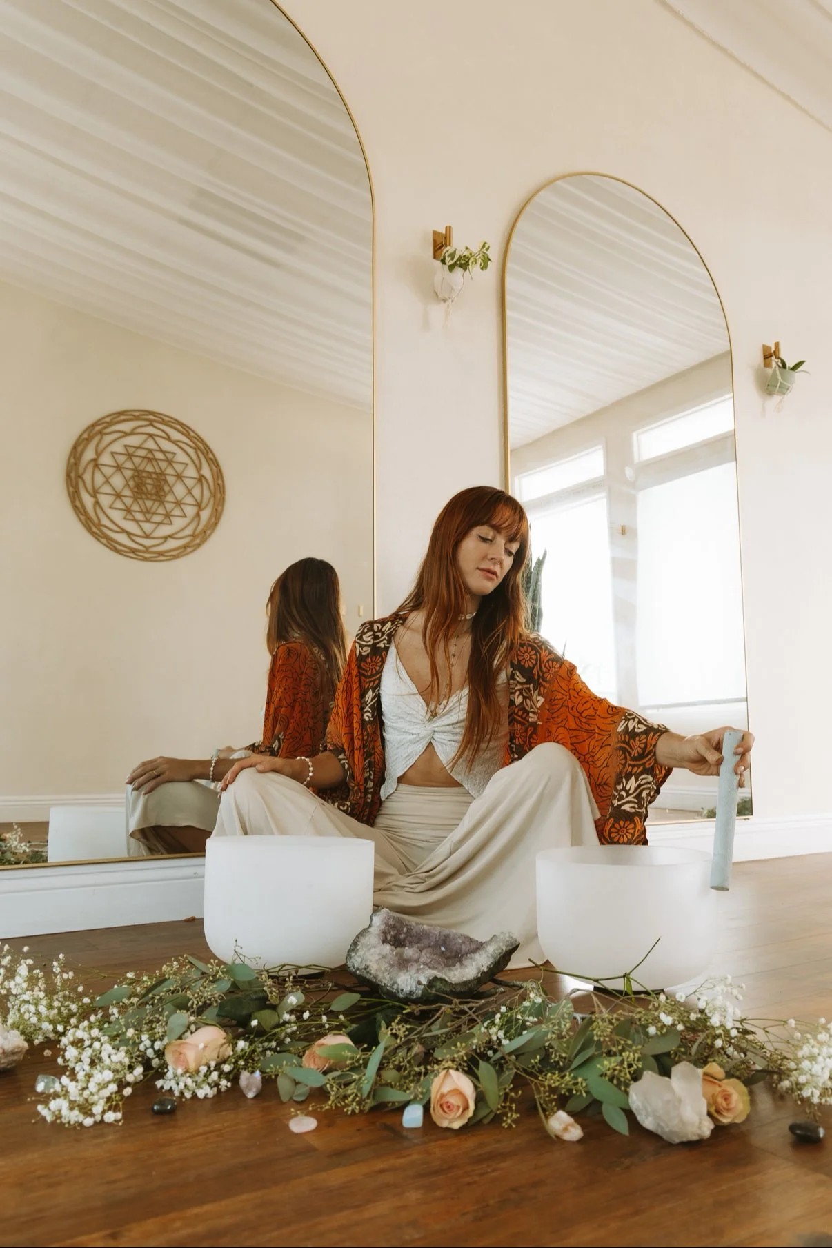 Woman playing crystal singing bowls for sound healing and spiritual growth