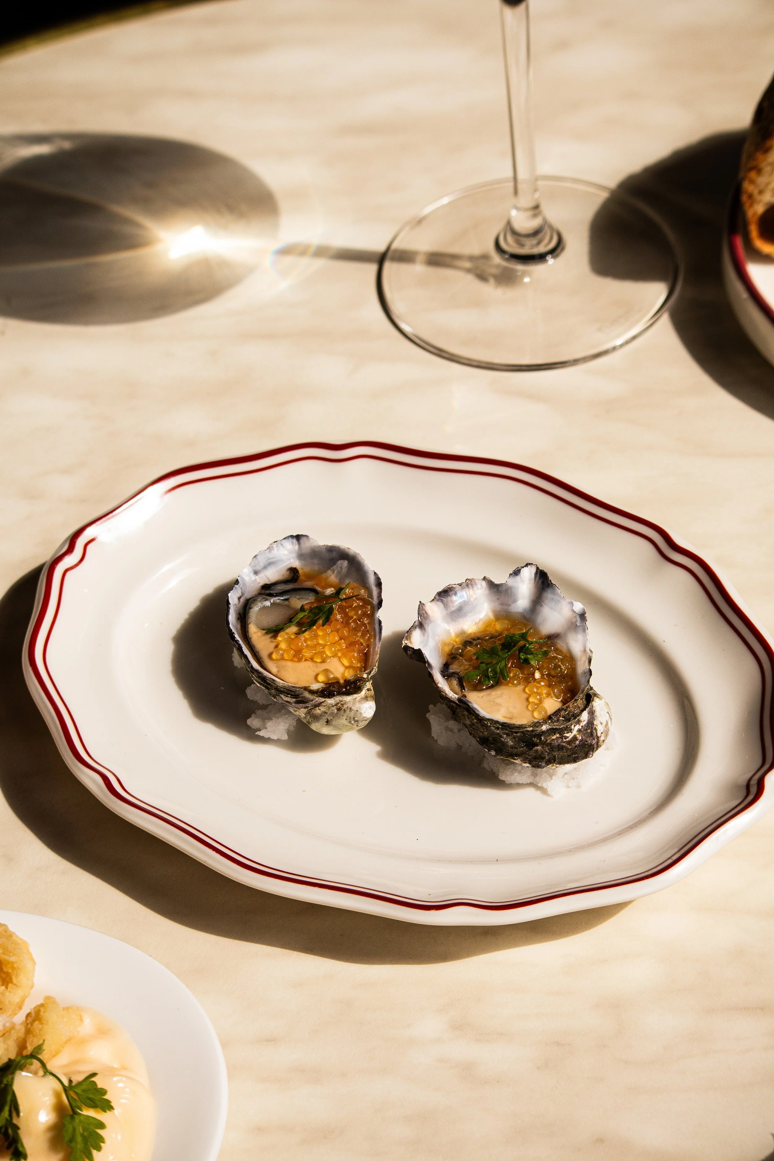 Close-up of two oysters with a wine glass at Annabel's Wine Bar