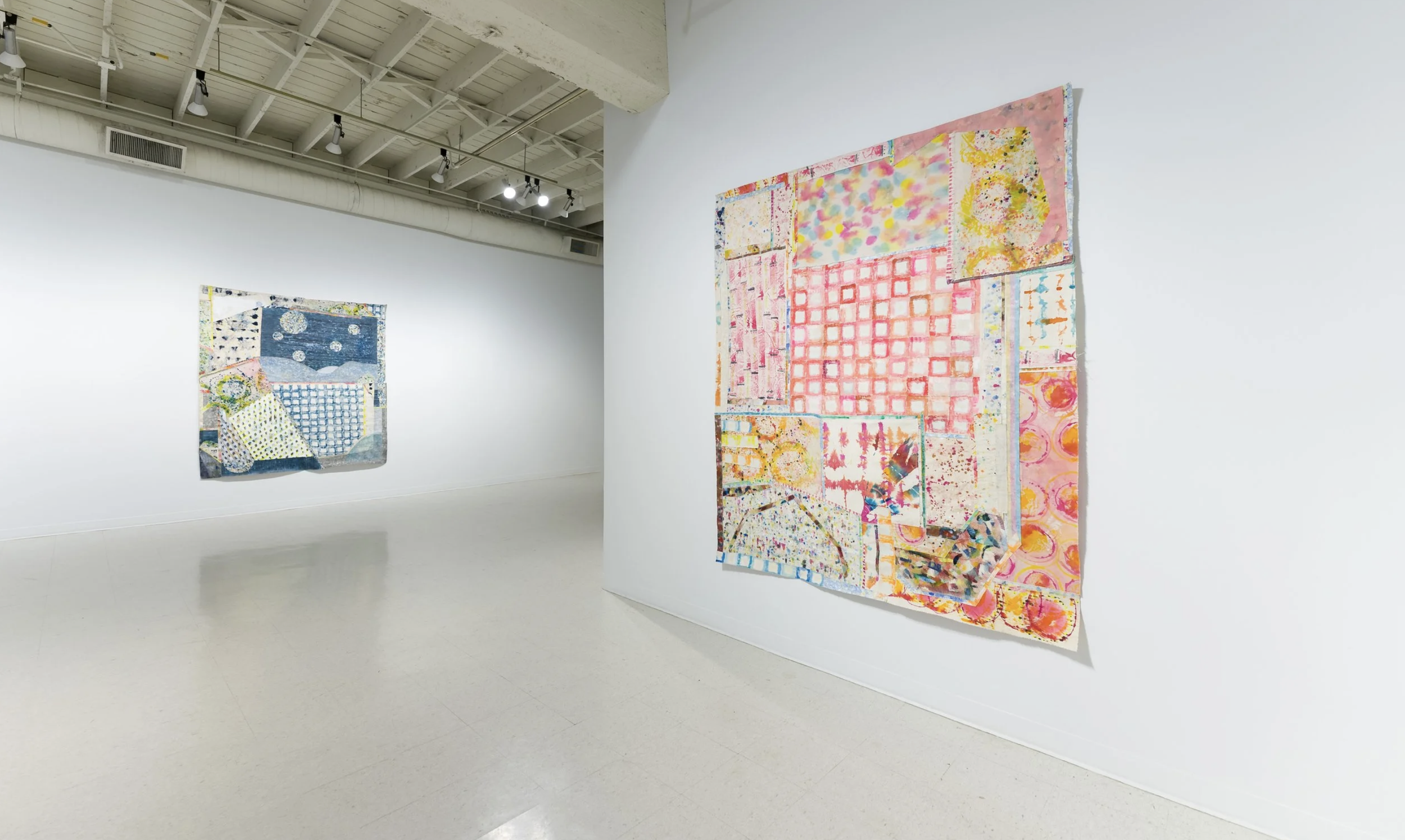 Gallery wall with colorful abstract quilt art installation in a modern art museum