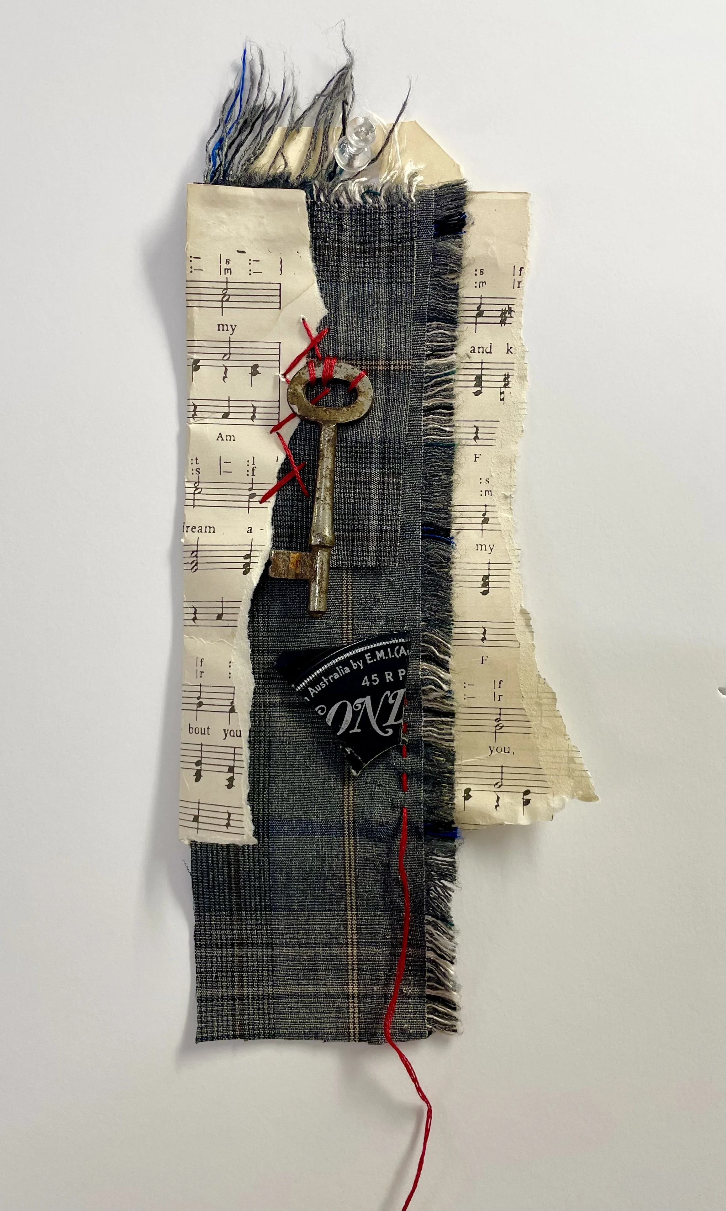 Red Thread. JANICE.. 2026 Layered textiles, paper, thread, found objects. 35 × 10 cm, unframed