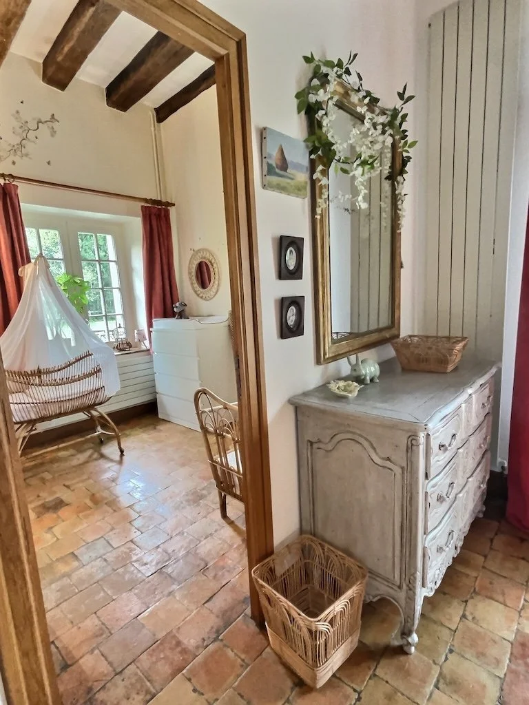 vue sur la chambre communiquante avec commode, miroir et berceau