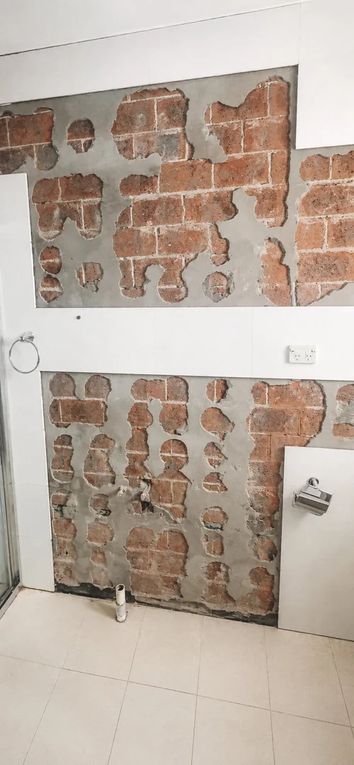 Bathroom wall tiles removed for repair