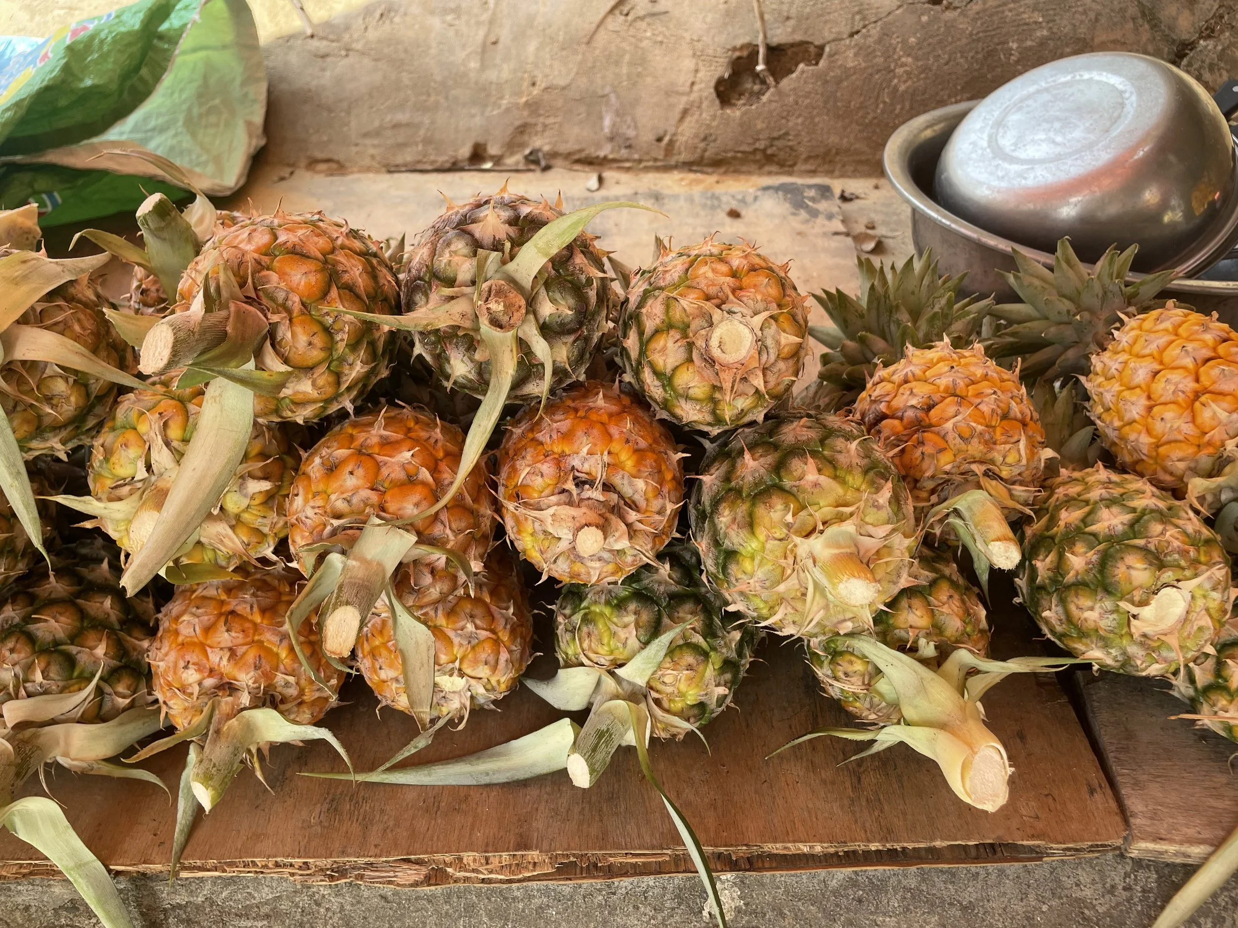 Heap of ripe pineapples on a wooden surface.
