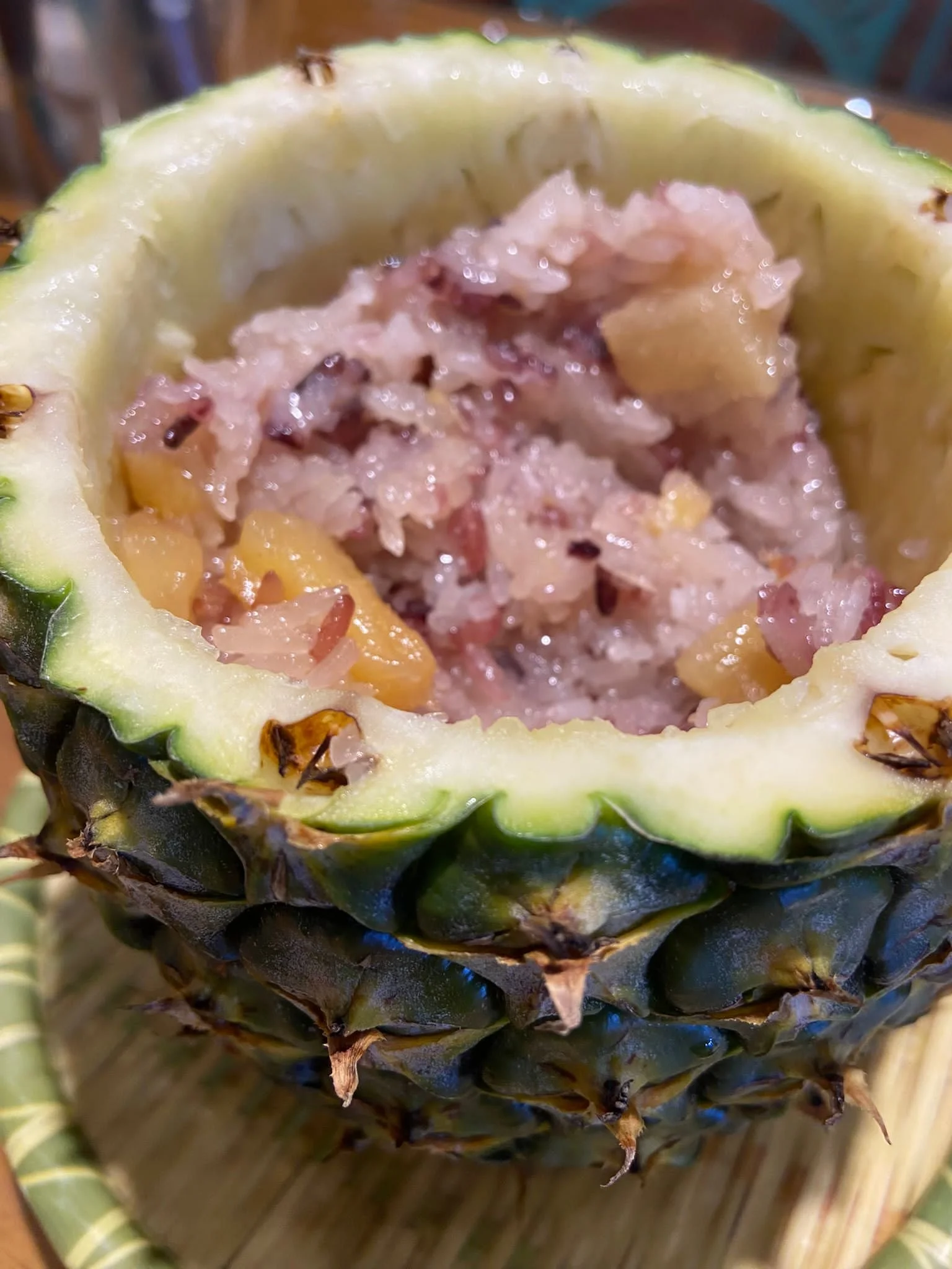 A hollowed-out pineapple filled with pineapple and rice mixture.