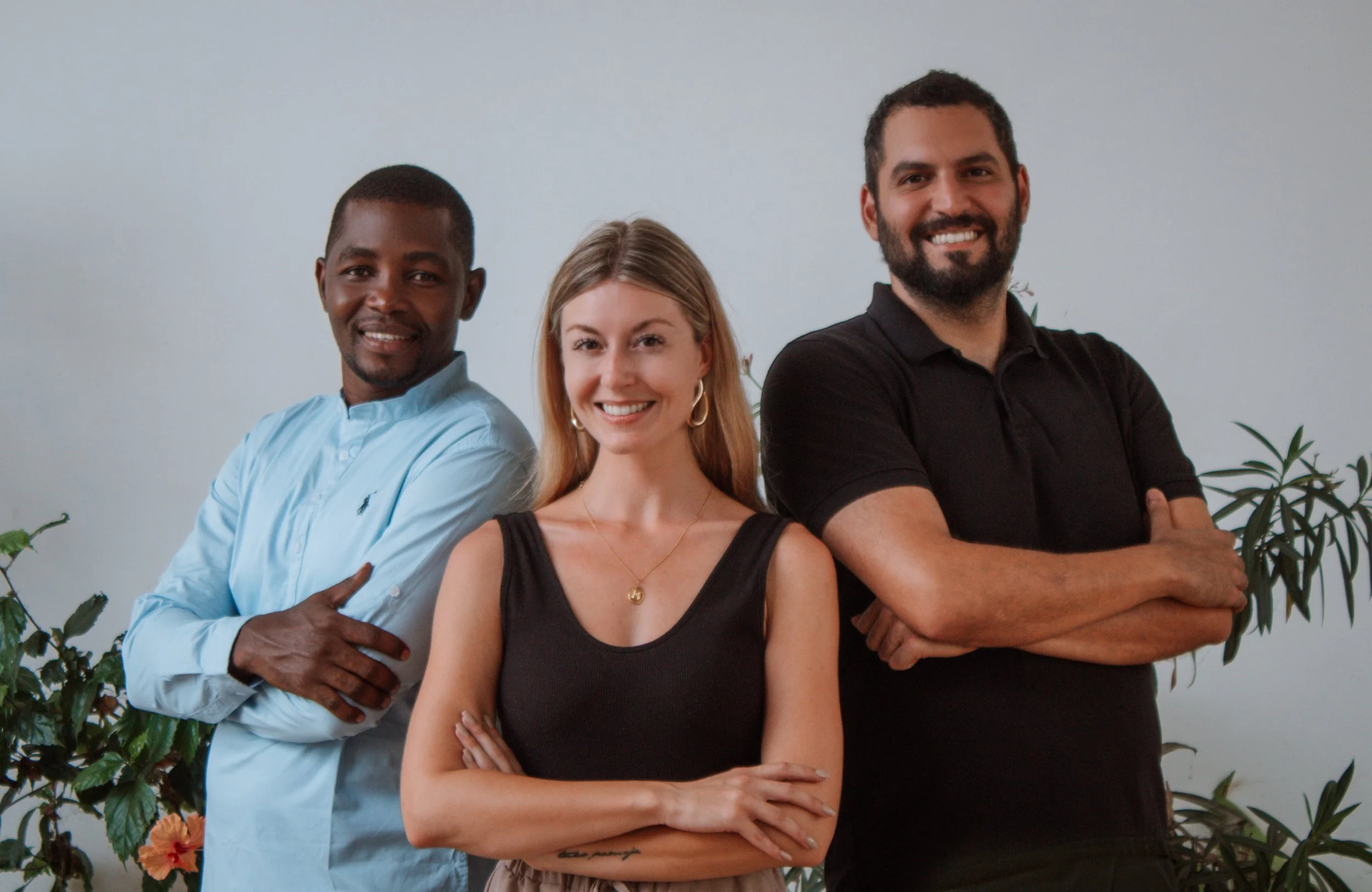 Three smiling team members standing with arms crossed, representing Sandbank Villas team.