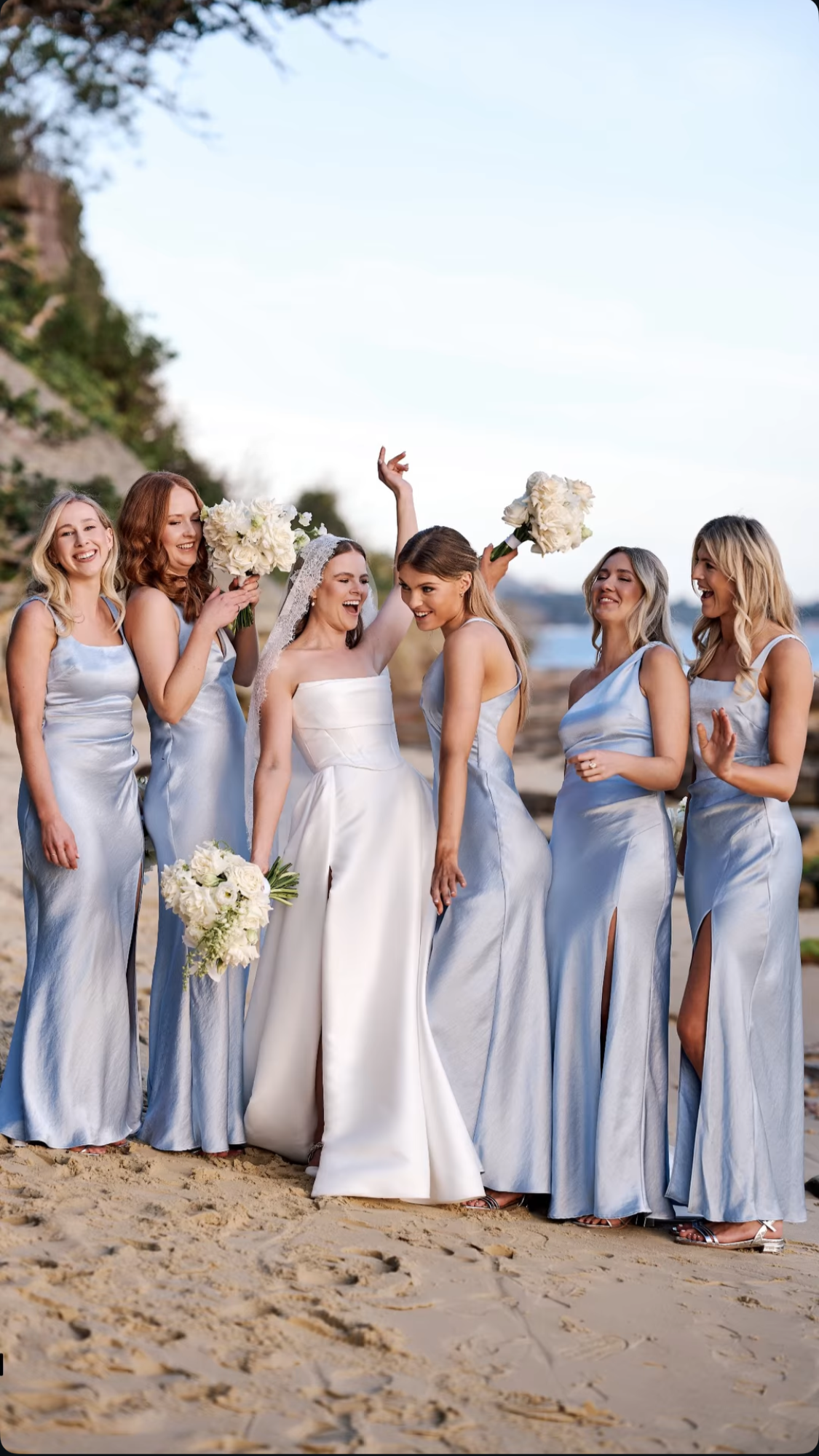 bride and bridesmaids drinking champagne with hair and makeup done