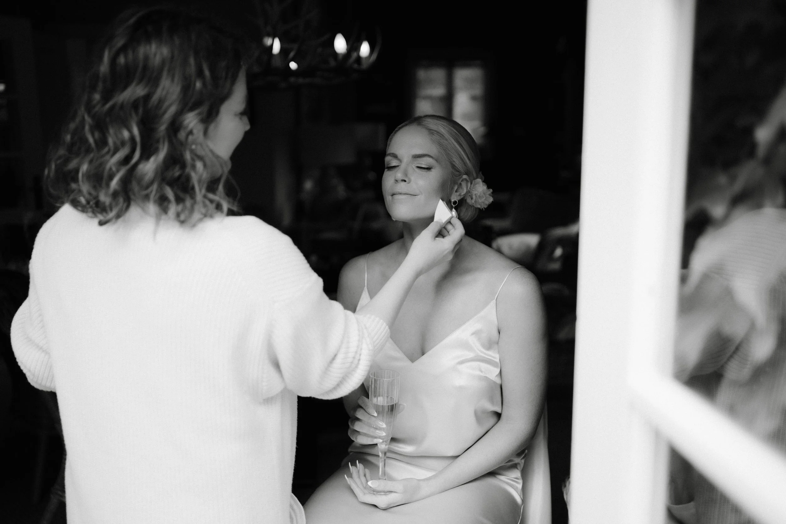 bride relaxing getting makeup done by makeup artist