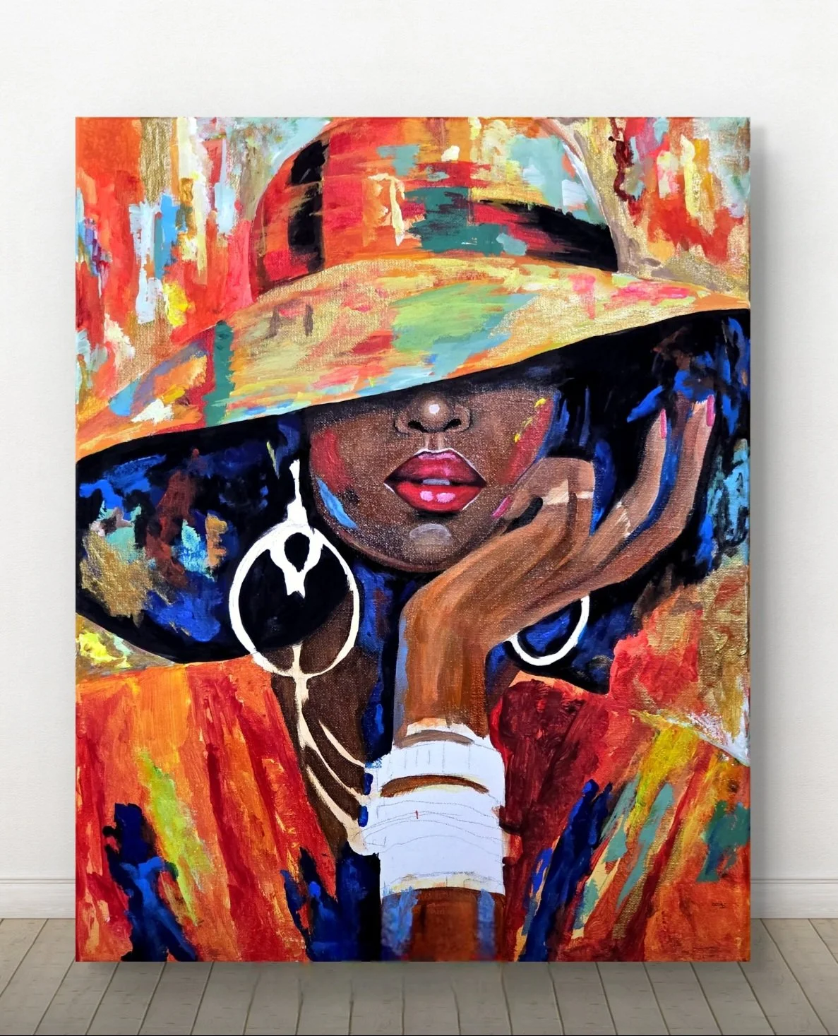 Colorful painting of a woman with dark skin, red lips, large white earrings, wearing a multicolored wide-brimmed hat, with one hand resting on her face, surrounded by vibrant abstract background.