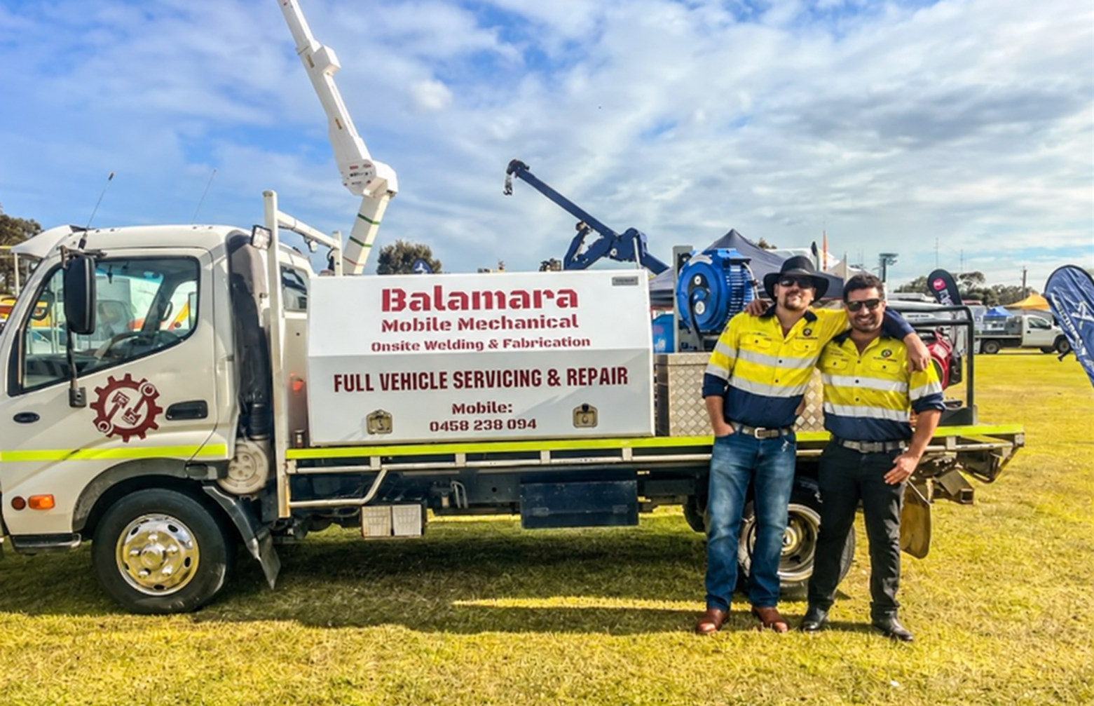 two balamara mechanics standing beside the Balamara service truck