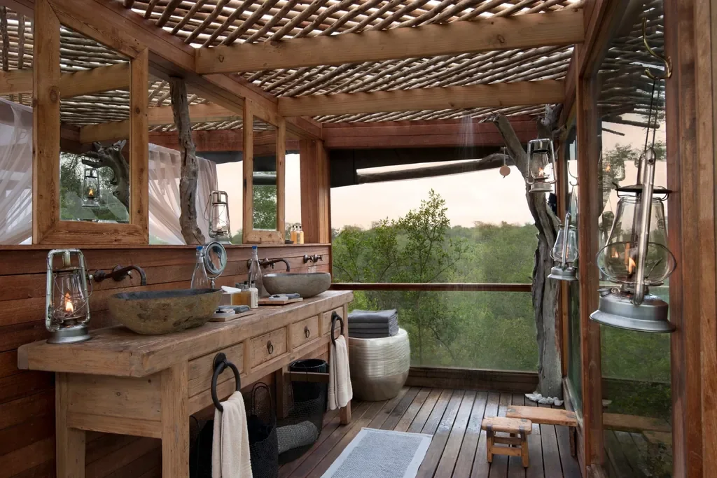 Open‑air Kingston Treehouse bathroom with twin stone basins and bush views, Lion Sands, Sabi Sand