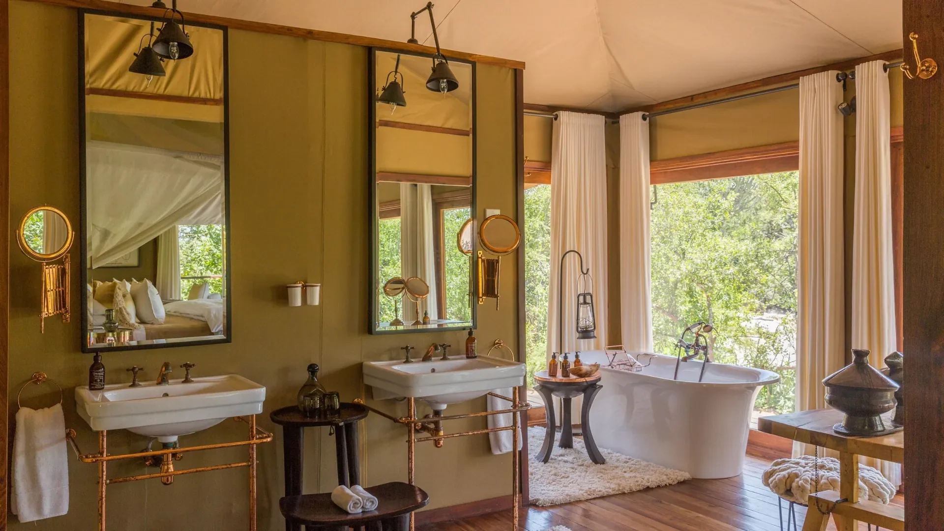 Freestanding bathtub with lantern and bush views at Mwiba Lodge in Tanzania