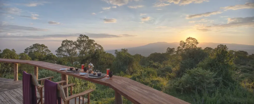 Breakfast setup on deck at The Highlands with sunrise views across Ngorongoro Crater rim