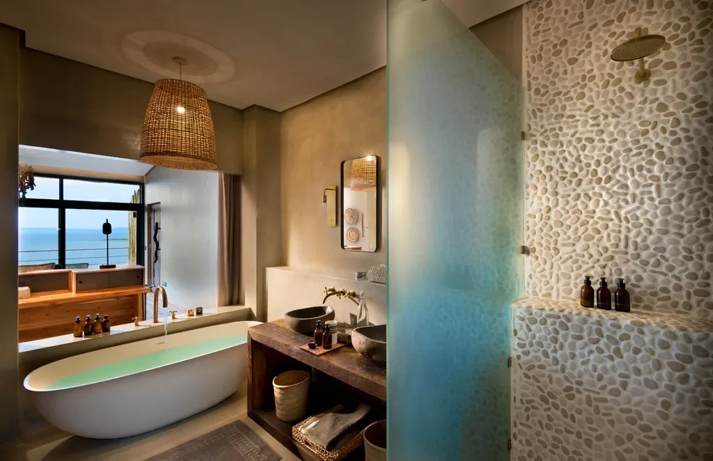 Luxury bathroom with freestanding tub and pebble shower, lake-facing suite at Bumi Hills Safari Lodge, Zimbabwe