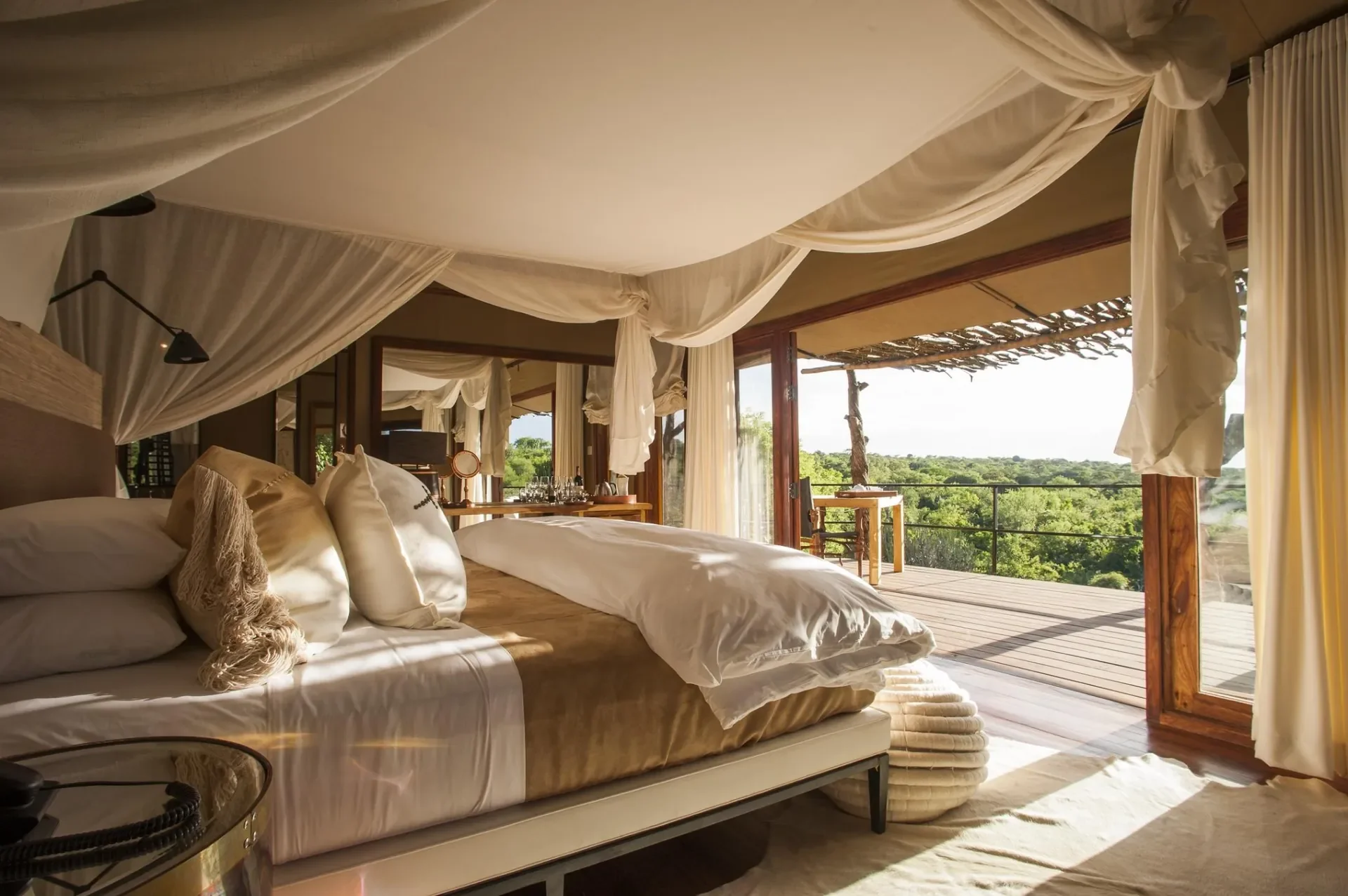 Mwiba Lodge tented suite bedroom opening to private deck with forest views in Tanzania