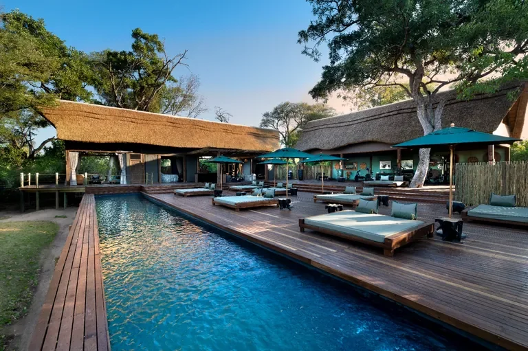 Lap pool with daybeds at Atzaro Okavango Camp safari lodge, Okavango Delta Botswana