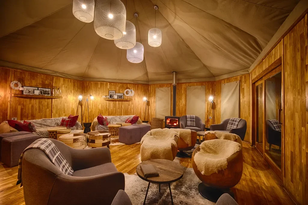 Warm lounge at The Highlands with wood burning stove and plaid accents, Ngorongoro highlands, Tanzania
