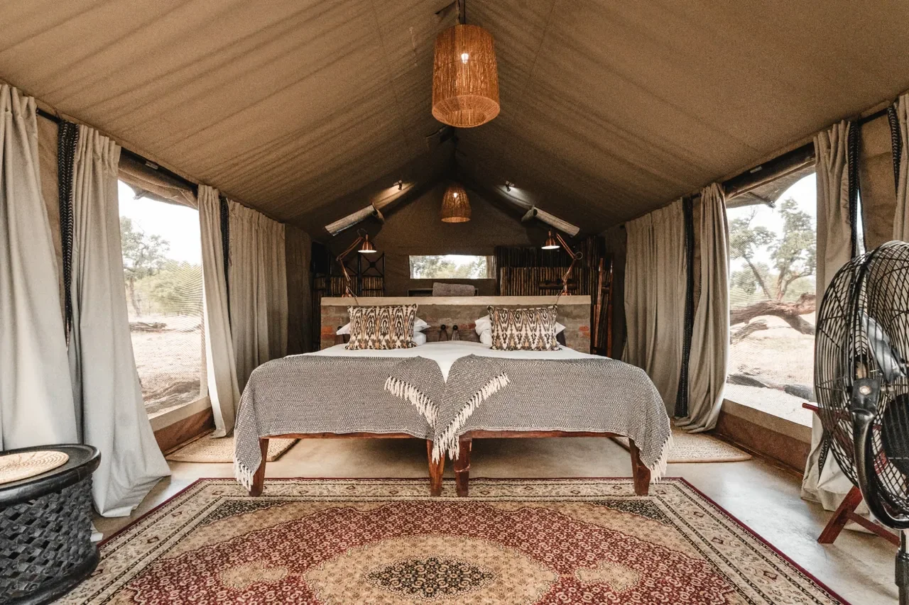 Davison's Camp tent bedroom interior, Hwange National Park Zimbabwe, twin beds with woven throws