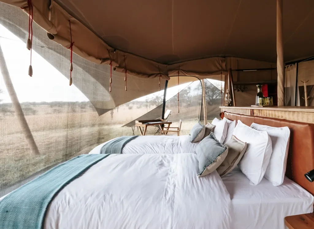 Usawa safari tent twin beds with mesh sides and savannah view in Serengeti National Park