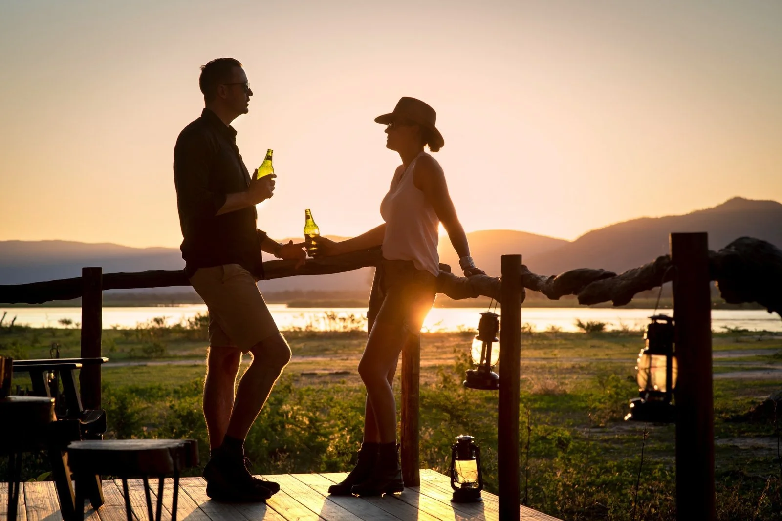 Couple having sundowner drinks on deck at Nyamatusi Mahogany, Mana Pools, Zimbabwe