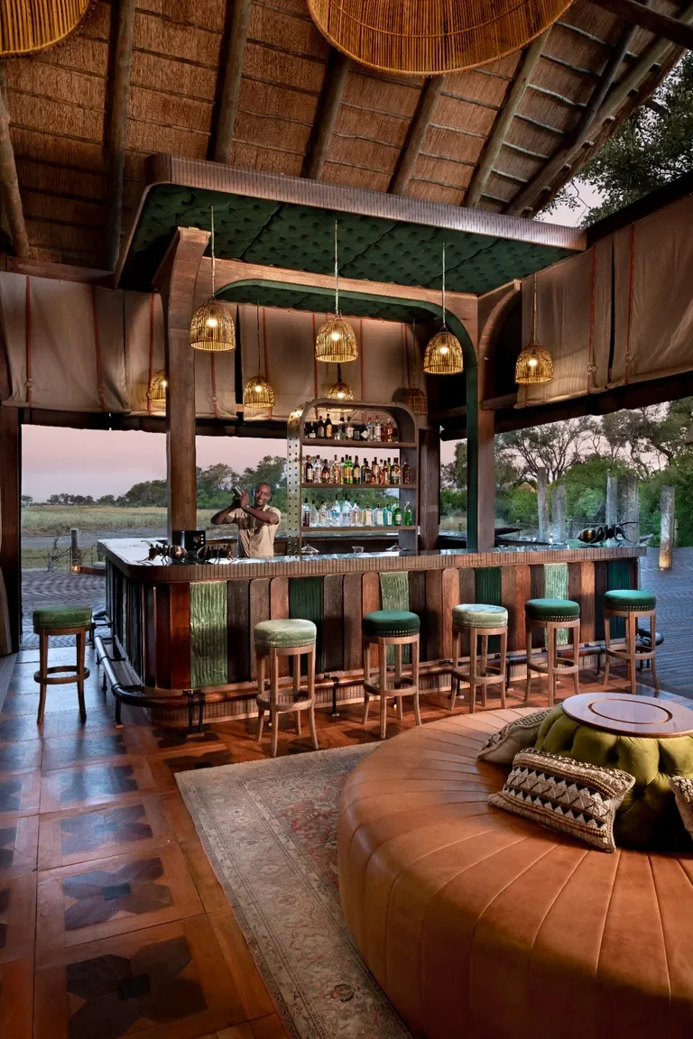 Artisanal cocktail bar at Atzaro Okavango Camp with thatch roof and pendant lights, Botswana