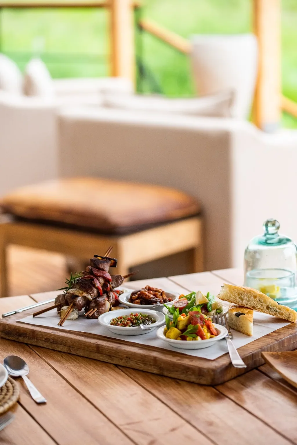 Dunia Camp Serengeti lunch platter with beef skewers, fresh salads and olive rosemary focaccia on the deck, Tanzania safari dining