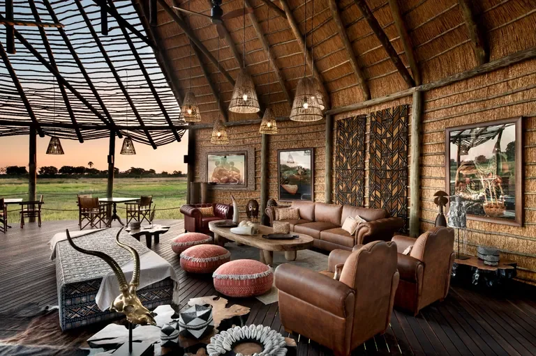Open-air lounge with thatch and African design at Atzaro Okavango Camp, Botswana