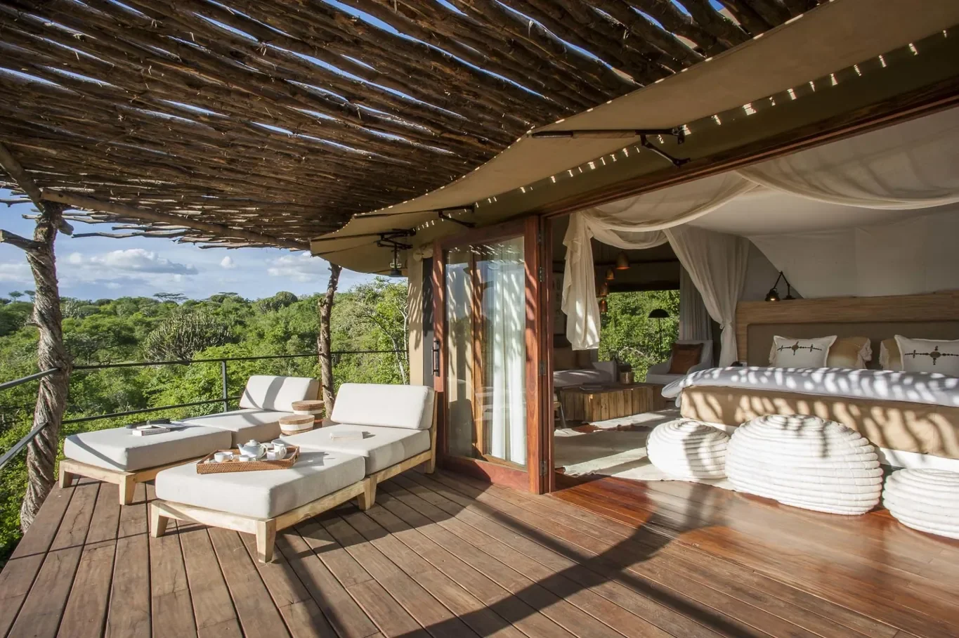 Private deck and bedroom of Mwiba Lodge suite, canopy daybeds overlooking Mwiba Wildlife Reserve