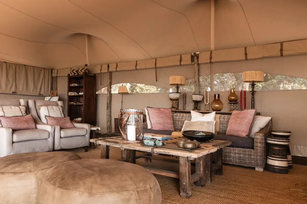 Little Ruckomechi safari lounge, canvas tent interior with woven sofa and rustic coffee table, Mana Pools National Park, Zimbabwe