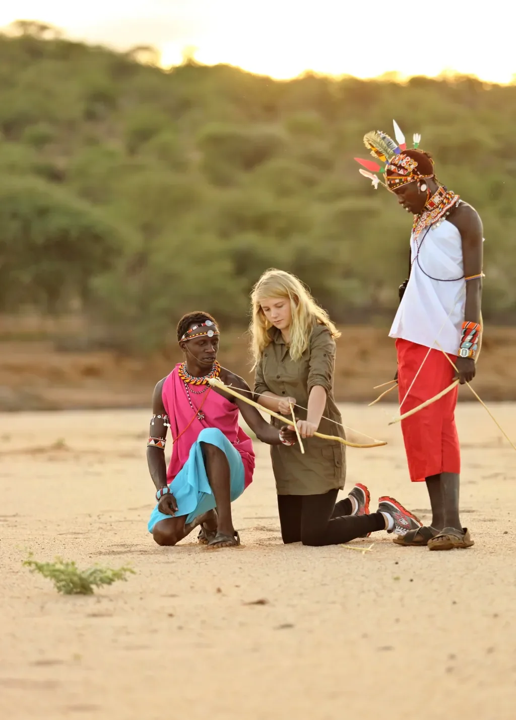 Samburu warrior teaching archery to a guest near Sasaab, Kenya