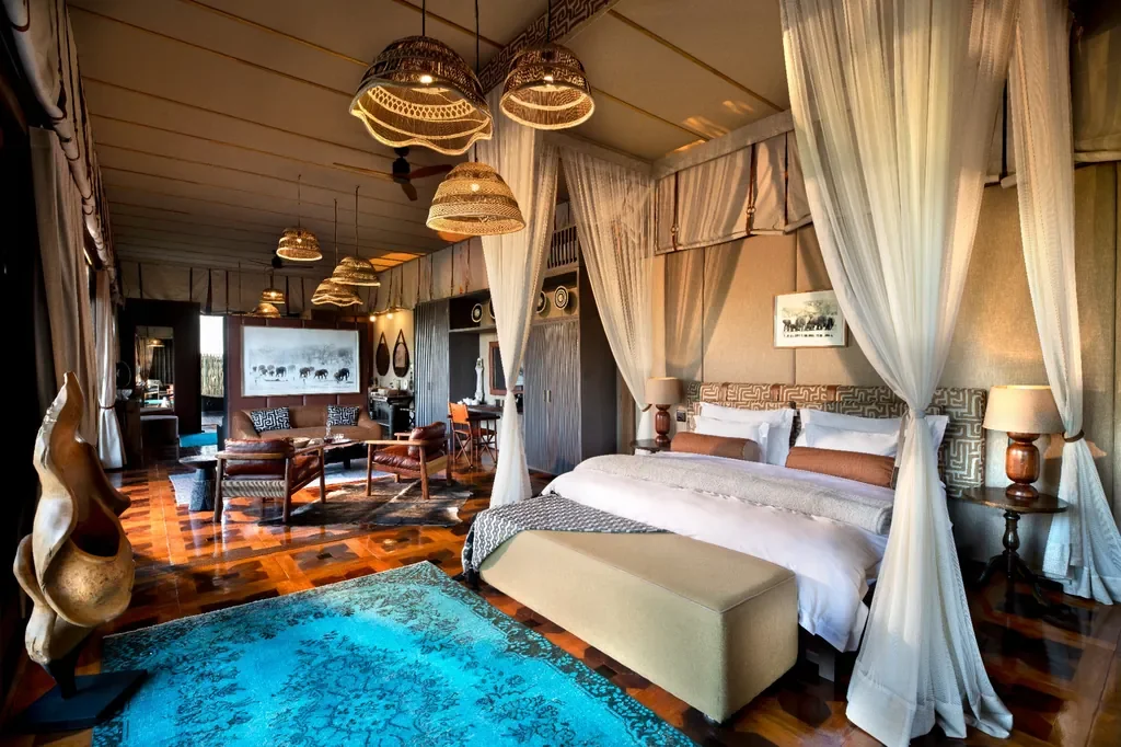 Atzaro Okavango Camp luxury tented suite with canopy bed and turquoise rug, Okavango Delta Botswana