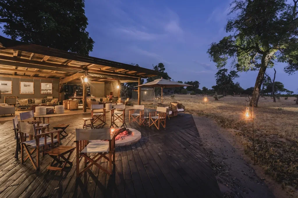 Davison's Camp main deck and firepit at dusk, Hwange National Park Zimbabwe, open-air lounge with lanterns