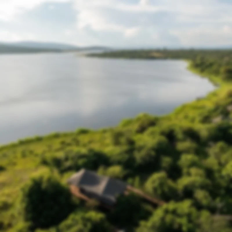 Aerial view of a river in Africa with green surrounding landscape and a house in the foreground.